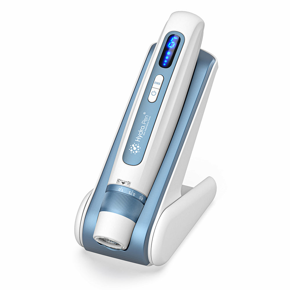 HydraPen H5 penna bianca e blu microneedling in piedi nel suo supporto di ricarica, dispositivo avanzato di microneedling per infusione di siero e trattamento della pelle.
